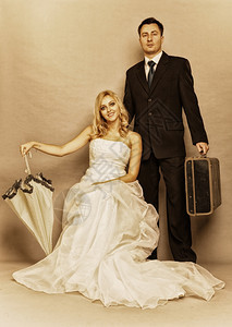 结婚日已的金发新娘肖像带雨伞金发新娘和带手提箱的新郎整个工作室拍摄Sepia彩色旧相片图片
