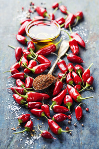 红辣椒和橄榄油覆盖木本底烹饪或辣食品概念图片