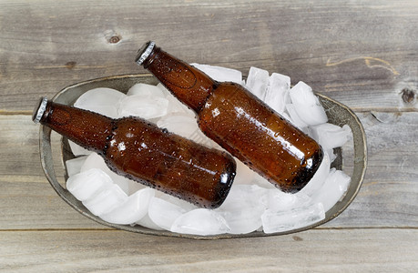 光天化日下看到瓶装啤酒在一桶新鲜真正的冰上露在外边图片