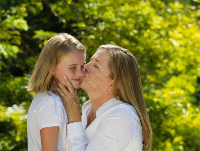 母亲吻她最小女儿时却在露天时将她的脸握在手边图片