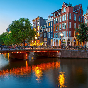 荷兰阿姆斯特丹运河典型的荷兰码头房屋和桥的夜间城市景象图片