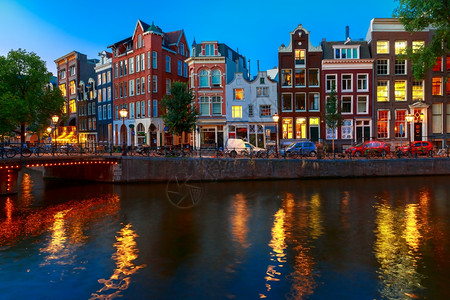 荷兰阿姆斯特丹运河典型的荷兰码头房屋和桥的夜间城市景象图片