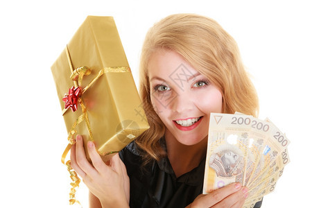 快乐的金发女孩年轻拿着黄金圣诞礼物盒和油币钞票图片