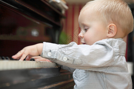 两岁小男孩在室内弹钢琴图片