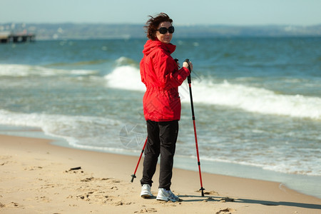 北欧人散步女在海滩上徒步旅行积极健康的生活方式图片