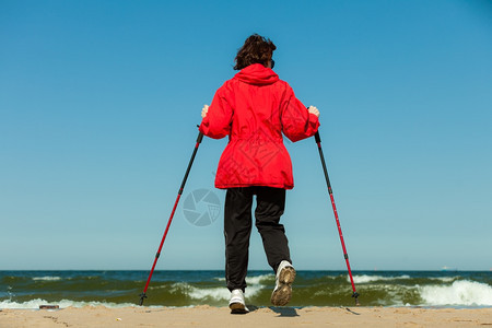 北欧人散步女在海滩上徒步旅行积极健康的生活方式图片