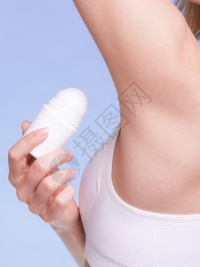 女身体的一部分女孩在臂窝中施用棒除臭剂年轻女将抗吸入剂放在下日常皮肤护理和卫生工作室中弹图片