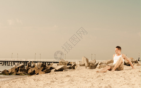 快乐暑假和人的概念时装肖像长满沙滩风景的英俊男子图片