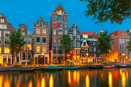 荷兰阿姆斯特丹运河典型的荷兰码头房屋和船只的夜间城市景象图片