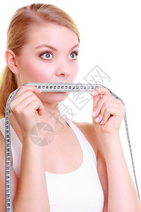 健美的女运动子用白色隔离的测量胶带遮住她的嘴唇图片