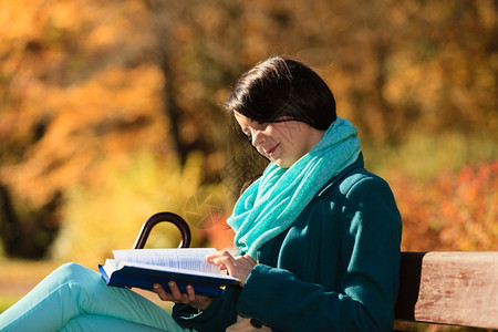 秋叶生活方式概念在秋季公园阅读书中临时女青年孩在休闲娱乐中放松图片
