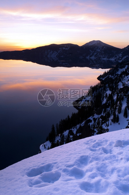 太阳升起照亮火山口湖的场景图片