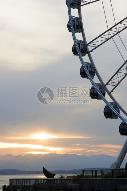 奥林匹克山和艾略特湾后面的日落前有费里斯轮子图片