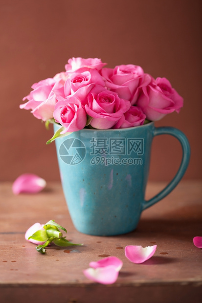 美丽的粉红玫瑰花束在杯中图片