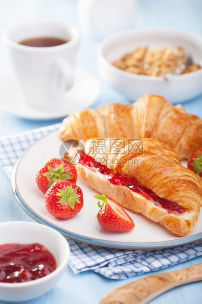 加果酱和草莓的新鲜羊角面包早餐用图片