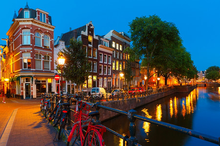 荷兰阿姆斯特丹运河夜间城市景象典型房屋和自行车桥图片