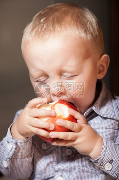 快乐的童年可爱小男孩肖像在家里吃苹果水健康的饮食和营养图片