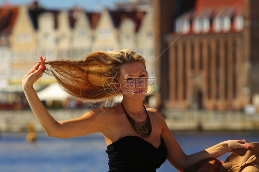 时尚的金发女旅行家在欧洲的城外古老镇格丹斯克图片