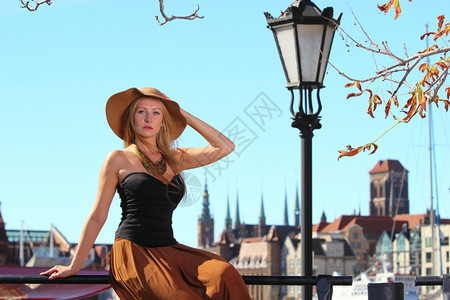 时尚的秋天旅行女游客在欧洲的古老城镇格但斯克图片