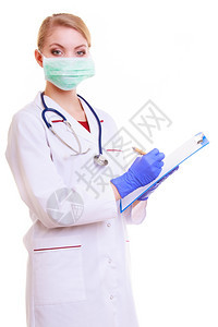 戴面罩和白大衣的妇女带听诊器的医生或护士在剪贴板上用笔写字的医生或护士被隔离医疗保险的务人员图片