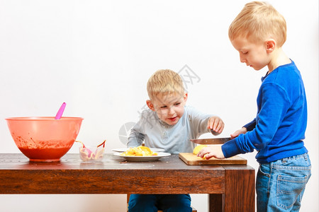 两兄弟玩危险游戏用厨房刀切苹果做沙拉背景图片