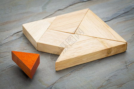 一个方形中缺少的一块方形是用tangram形状构建的传统拼图游戏石块岩背景图片