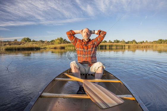 在独木舟上享受阳光的老年人图片