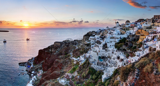 希腊圣托里尼岛的奥亚镇日落时在希腊传统和著名的风车停在卡尔德拉悬崖上爱琴海图片