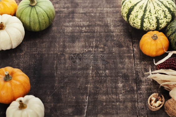 南瓜和玉米在旧木制桌上的秋边框架感恩节概念图片