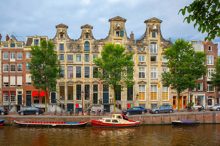 荷兰阿姆斯特丹运河和典型房屋船只和自行车的城市景象图片