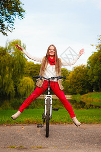 年轻女郎在公园骑着自行车一起玩特技图片