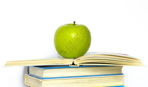 供学校使用的绿苹果和一堆书背景图片