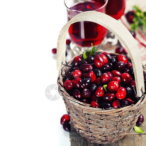 将红莓放在篮子和果汁上放在木制背景的果汁上图片