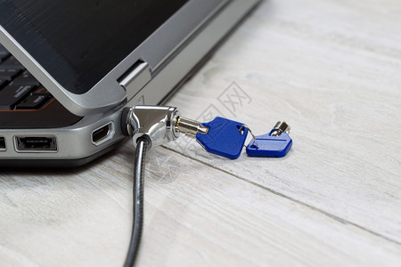 固定的实物安全锁和钥匙有计算机和固定的铁制白色木板背景链的锁和钥匙图片
