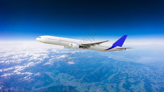 云上方的一架白色飞机在蓝天中飞翔图片