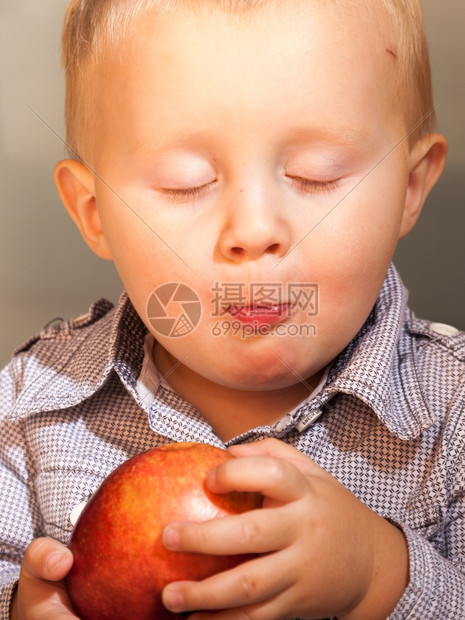 快乐的童年可爱小男孩肖像在家里吃苹果水健康的饮食和营养图片