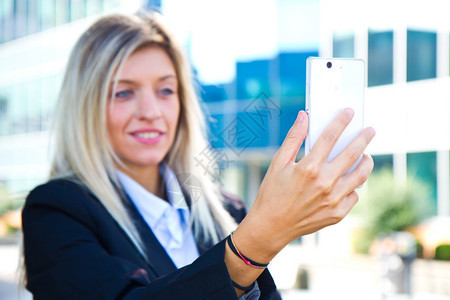 美丽的女商人用手机拍自图片