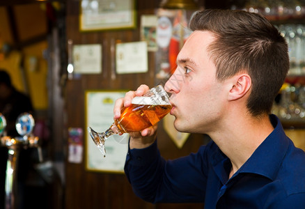 深思熟虑的男人在酒吧喝啤的肖像图片