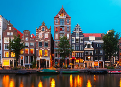 荷兰阿姆斯特丹运河典型的荷兰码头房屋和船只的夜间城市景象图片