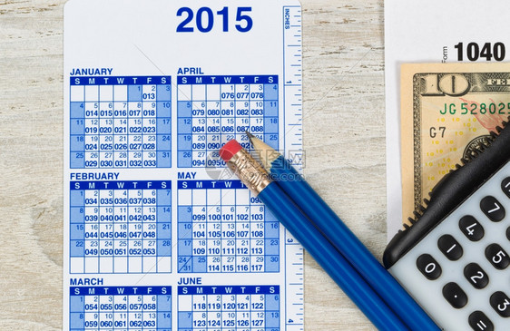 美国税表104包括计算器日历货币和木制桌面xA的铅笔图片