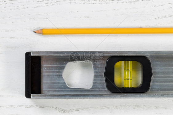 在白板上贴近金属平面工具和黄铅笔图片