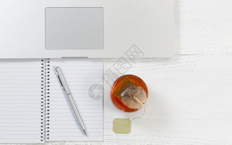 桌面的顶端角度拍摄上面有笔记本电脑和茶杯里面有袋水平格式图片