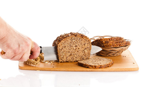 新鲜面包在切肉板上布兰面包手在木板上切面包图片