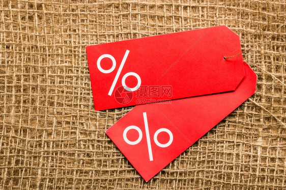 购物和销售概念两个红色价格标签布表面背景上有百分数符号复制空间图片