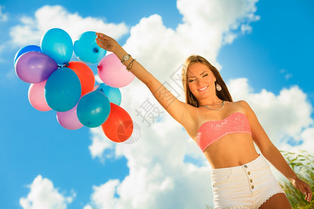 暑假庆祝活动和生方式概念吸引有力的少女孩在海滩蓝天空背景上外面有彩色气球图片