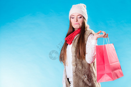 冬妇女穿着温暖的衣服穿着蓝色的红纸袋有趣的女孩在买卖和零售图片