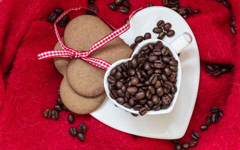咖啡爱概念心形白杯咖啡豆和甜饼干姜带红布背景的丝图片
