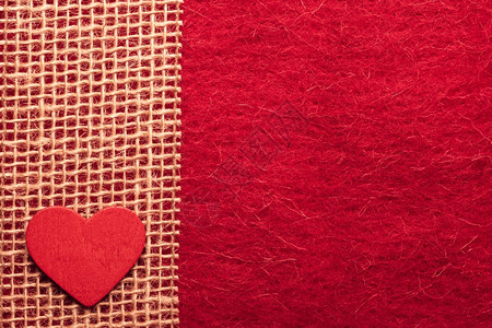情人节或婚礼概念木质装饰心脏在抽象的红布背景上撕裂丝带边界框架图片