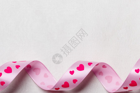 情人节或婚礼概念粉红的心带在抽象白布背景上复制空间曲线框架图片