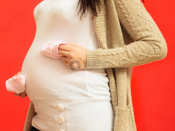 怀孕母亲和幸福概念孕妇为未出生婴儿穿小鞋靴的孕妇图片